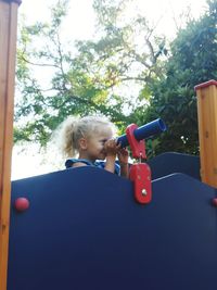 Girl playing with toy against trees