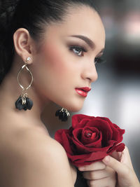 Close-up of woman with red rose