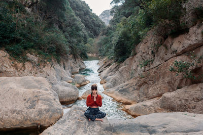 Relaxed woman practicing the meditation in the river