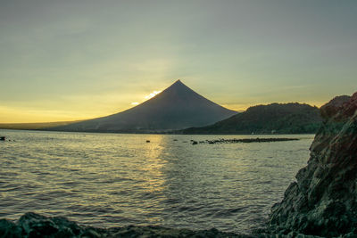 Mayon volcano scenic view of sea against sky during sunset