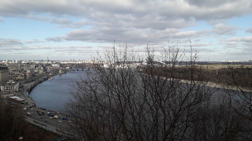 Scenic view of river by buildings against sky