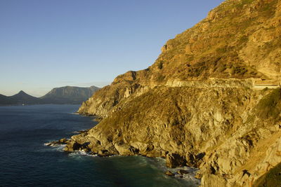 Scenic view of sea and mountains against clear sky