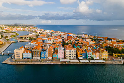 High angle view of townscape by sea against sky