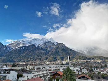 Aerial view of townscape and mountains against sky