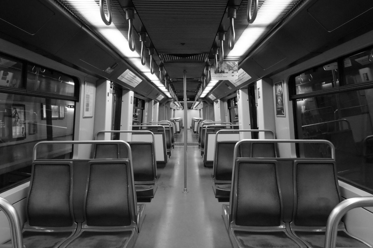 indoors, empty, in a row, absence, vehicle seat, chair, seat, interior, order, transportation, repetition, illuminated, public transportation, no people, arrangement, ceiling, large group of objects, vehicle interior, modern, diminishing perspective