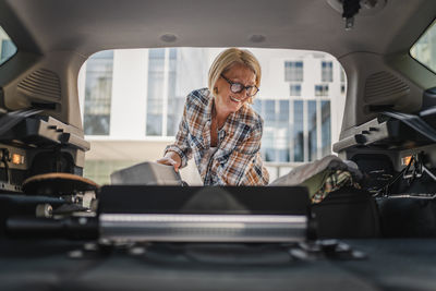 Portrait of young woman sitting in car
