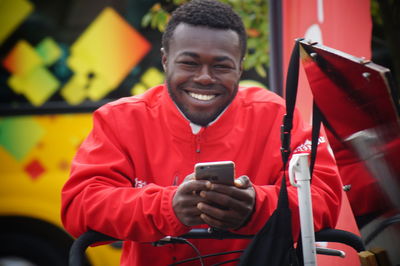 Portrait of smiling man holding mobile phone