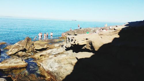 Rear view of people standing on beach