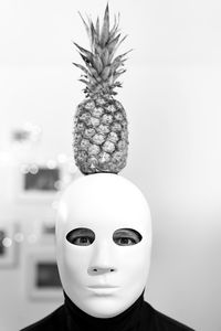 Mask man carrying pineapple on head