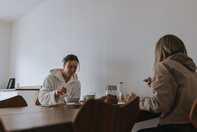 Women sitting at table and eating breakfast