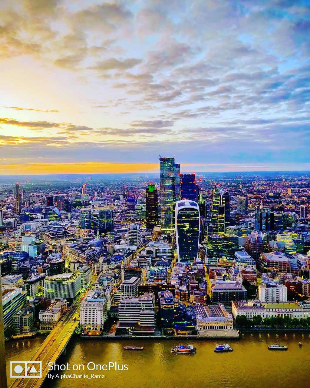 HIGH ANGLE VIEW OF BUILDINGS AND CITY AGAINST SKY DURING SUNSET