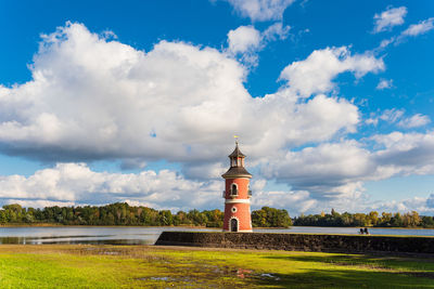 Lighthouse by sea against sky