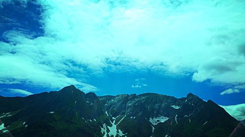 Scenic view of mountains against blue sky