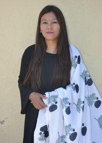 Portrait of woman standing against wall