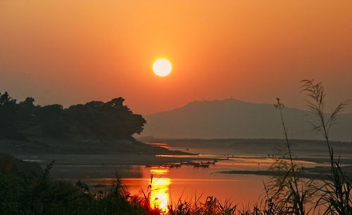 Scenic view of lake against orange sky