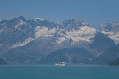 Scenic view of sea and snowcapped mountains against sky