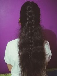 Rear view of woman standing against wall