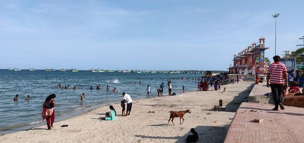 People at beach against sky