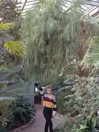 Full length portrait of man standing by plants