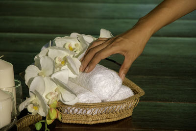 Midsection of woman holding white flowering plants in basket