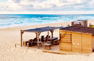 Chairs on beach against sky