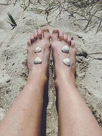 Low section of woman on sandy beach