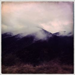 Scenic view of mountains against cloudy sky