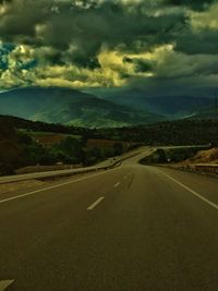 Country road against cloudy sky