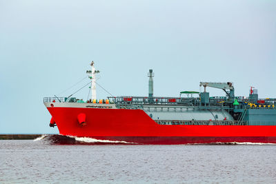 Red ship in sea against clear sky