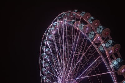 Low angle view of illuminated ferris wheel against sky at night