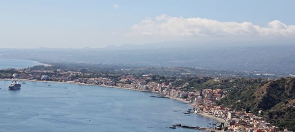 High angle view of city by sea against sky