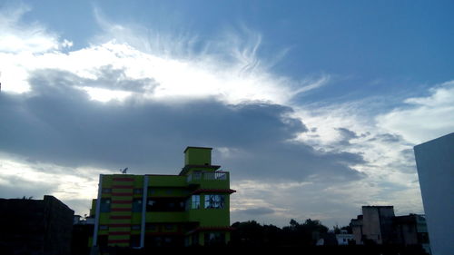 Low angle view of buildings against cloudy sky