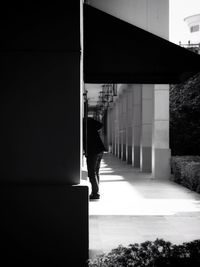 Rear view of silhouette man standing by building