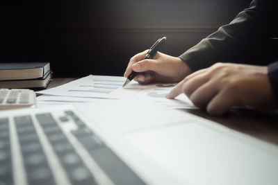 Midsection of person using laptop on table