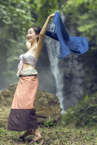 Woman wrapped in fabric on rock