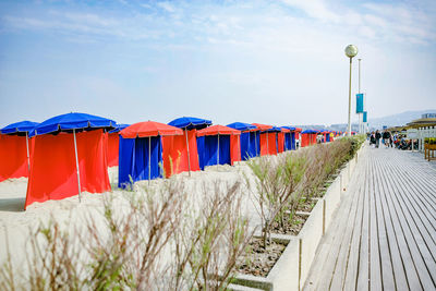 Row of multi colored umbrellas on beach against sky