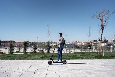 Side view of young man standing against clear sky