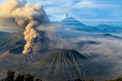 Smoke emitting from volcanic mountain against sky