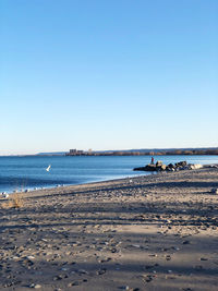 Scenic view of beach against clear blue sky