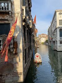 Boats in canal amidst buildings in city