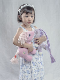 Girl looking away while holding toys