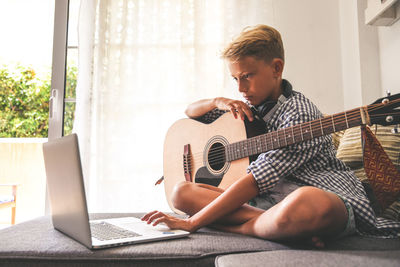 Man playing guitar at home