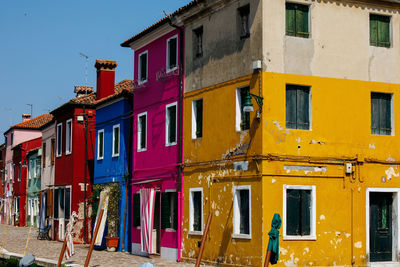 Vibrant houses along the canal in burano, italy, highlight unique architecture 