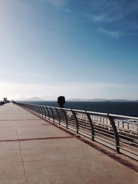 Pier by sea against clear sky on sunny day