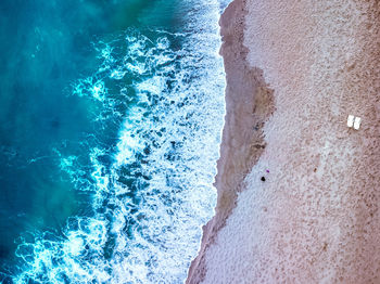 Aerial view of waves flowing on shore at beach