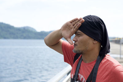 Portrait of young man in sea against sky