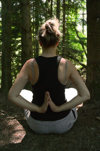 Woman standing on tree trunk