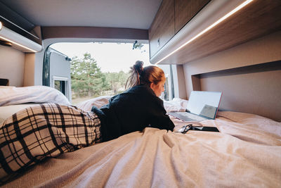 Young woman using laptop in camper