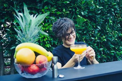 Portrait of smiling young woman holding drink