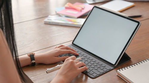 Midsection of man using mobile phone on table